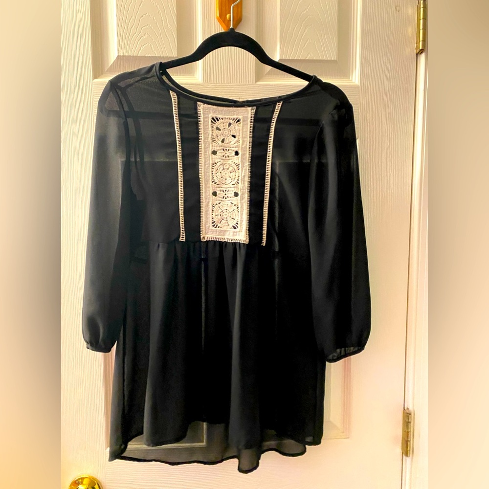 Black see through shirt with decorative white fabric on the front in the middle